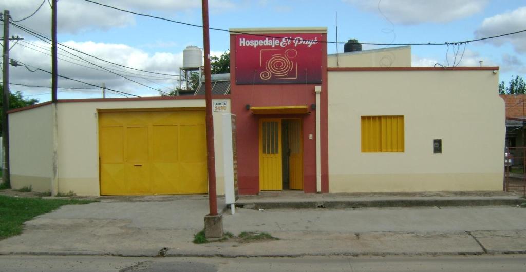 ein Gebäude mit gelben Türen und einem Schild darauf in der Unterkunft Hospedaje El Paye in Corrientes
