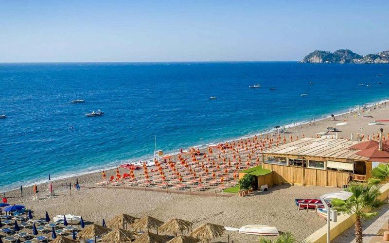 - une plage avec des chaises et des parasols et l'océan dans l'établissement A&G Casa Vacanze Naxos-Taormina, à Giardini Naxos