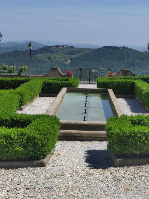 a swimming pool in the middle of a garden at Dépendance in Villa Albachiara e Primaluce in Carmignano