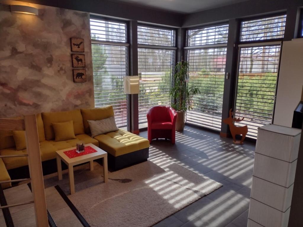 a living room with a yellow couch and a table at Apartament Łoś i Ryś in Zła Wieś Wielka