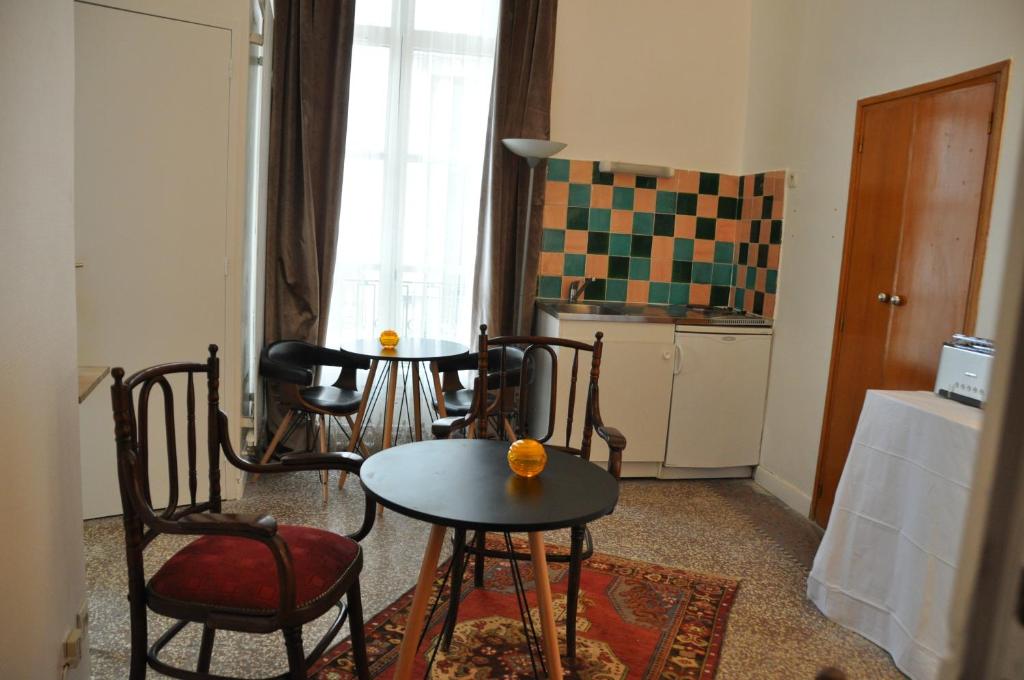 Una sala de estar con mesa y sillas y una cocina. en Ida Chambres d'hôtes B&B, en Montpellier