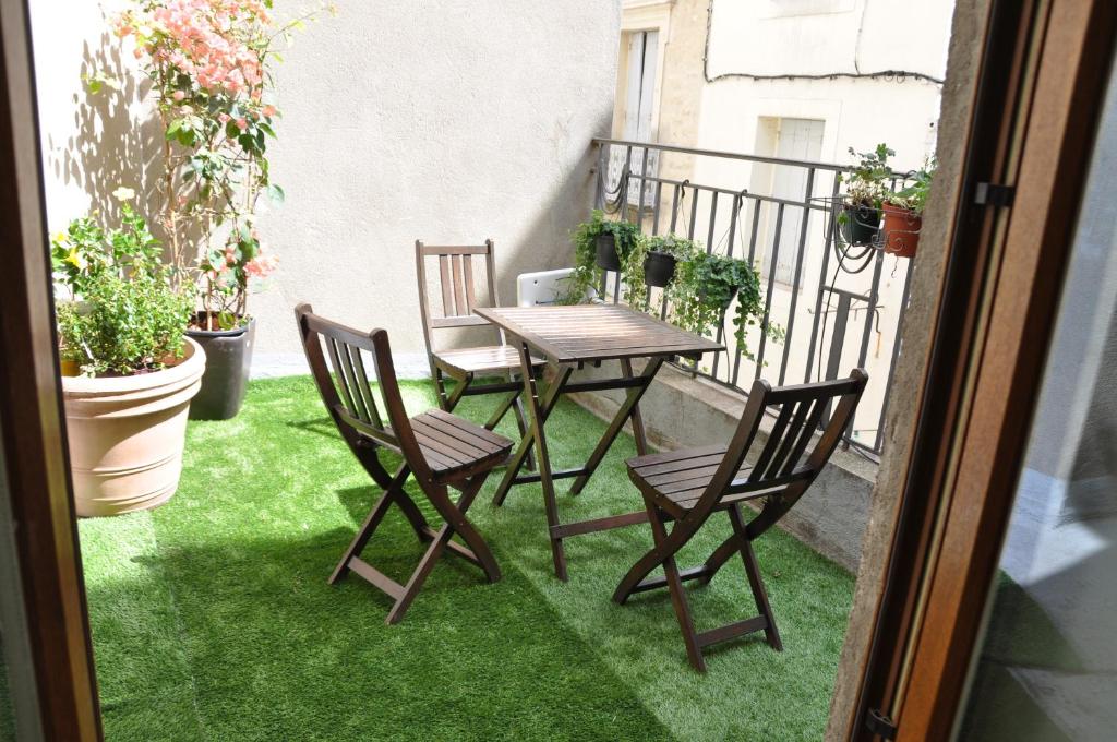 einen Tisch und Stühle auf einem Balkon mit grünem Gras in der Unterkunft Ida Chambres d'hôtes B&B in Montpellier