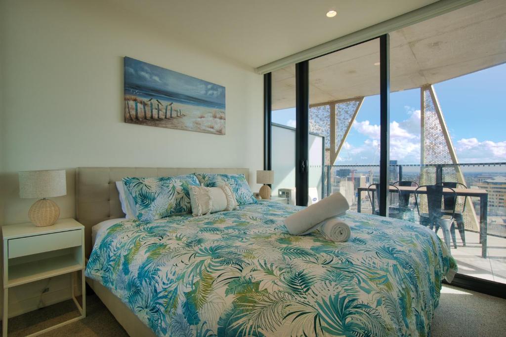 a bedroom with a bed with a view of a balcony at King Bed Luxury CBD Coastal Room with Amazing City Views, Spa, Gym, BBQ, Steam & Sauna Rooms in Adelaide