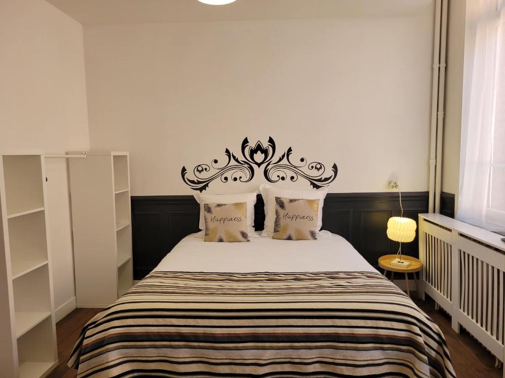 a bedroom with a bed with a black headboard at Studio 1 du Temple Hyper Centre in Cambrai