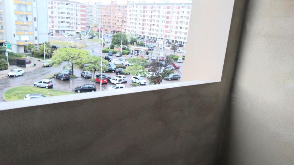 uma vista de um parque de estacionamento a partir de uma janela em monolocale 2 LudoLeo 5p em Quartu SantʼElena