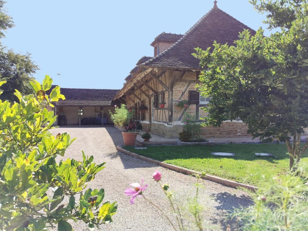 una casa con un jardín delante de ella en La ferme de la Terve, en Bruailles