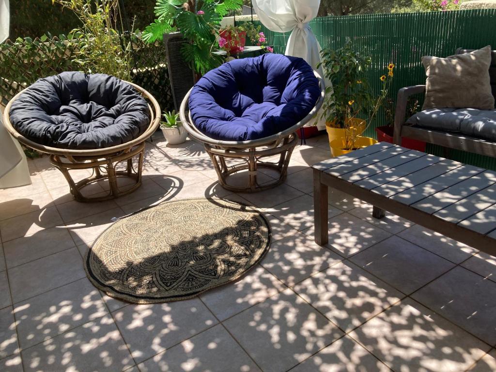 two chairs and a table on a patio at B&B Macchia Verdata avec piscine in Monacia-dʼAullène