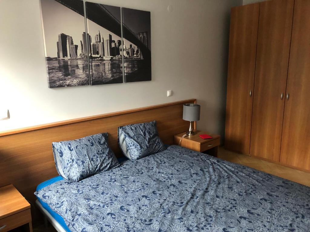 1 dormitorio con 1 cama azul y 2 almohadas en Apartament Dadaj 2/5, en Dadaj