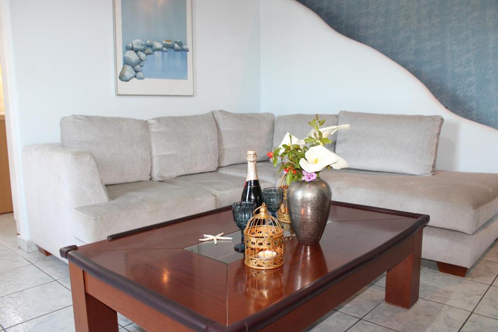 a living room with a couch and a table with wine bottles at Stardust, the studio in Adamas