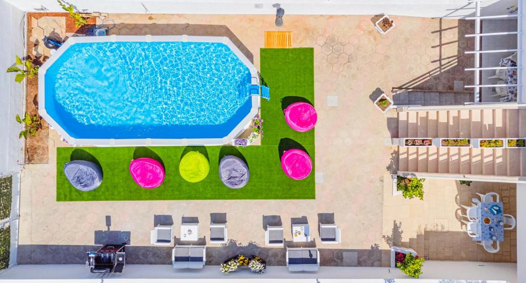 een uitzicht op een zwembad met groen gras en roze bij Chiara & Giulia Apartments by HDSalento in Leuca