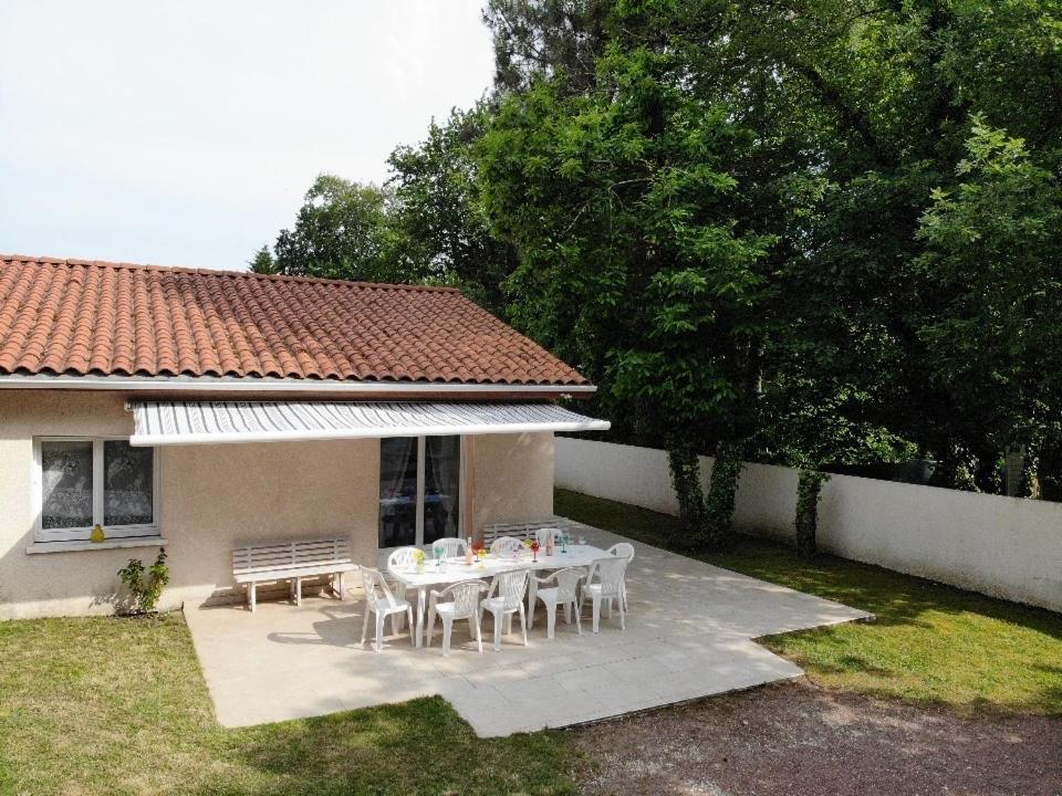 einen Tisch und Stühle im Hinterhof eines Hauses in der Unterkunft Maison Royan 3 chambres avec salle d'eau, piscine in Royan