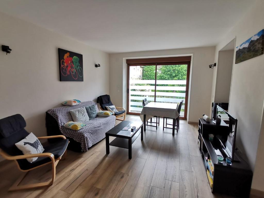 ein Wohnzimmer mit einem Sofa und einem Tisch in der Unterkunft Appartement Fontargente in Ax-les-Thermes