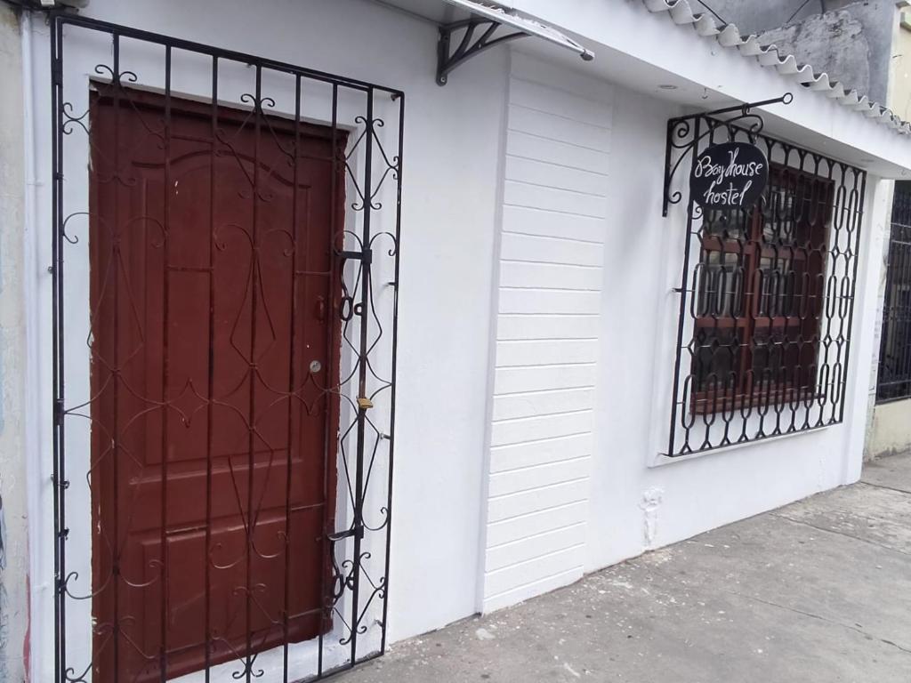 a red door on the side of a building at Alquiler de habitaciones BAY HOUSE HOSTEL in Salinas