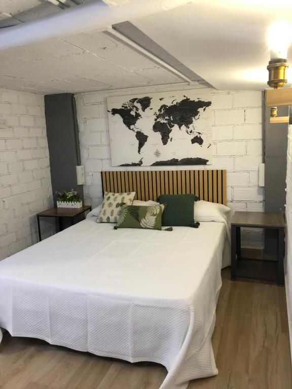 a bedroom with a large white bed with a map on the wall at Loft 2 , San Ignacio Maracena in Maracena