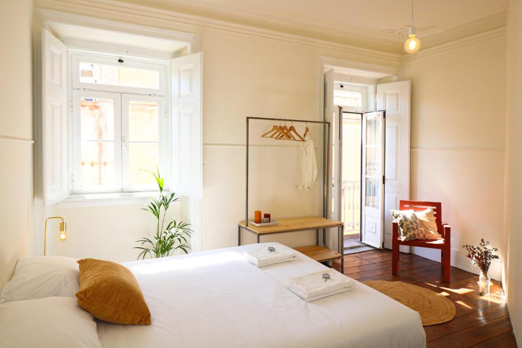 una camera da letto con un letto bianco e una finestra di Chalet Santa Rita - STUNNING APT. NEXT TO THE SEA a Estoril