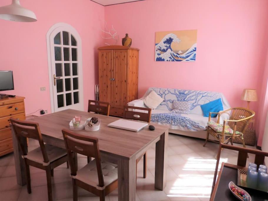 a living room with a table and a bed at Casa Rosa Marina di Cecina in Cecina