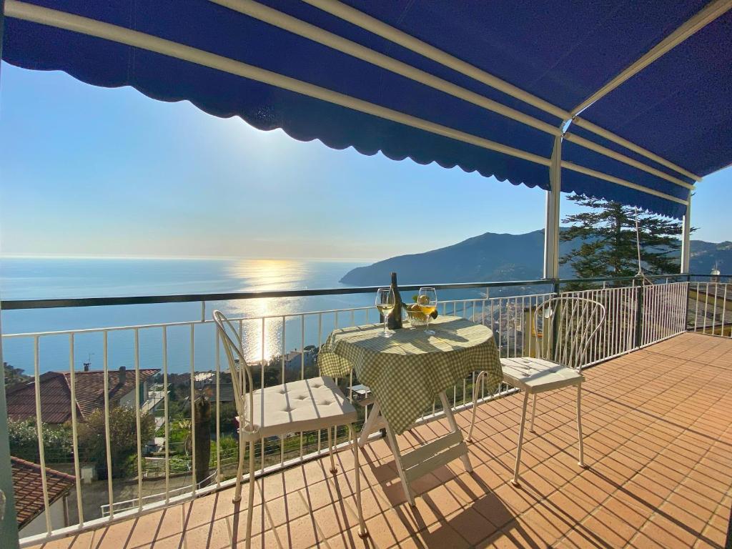 - un balcon avec une table, deux chaises et un parasol dans l'établissement Appartamento Moneglia, à Moneglia