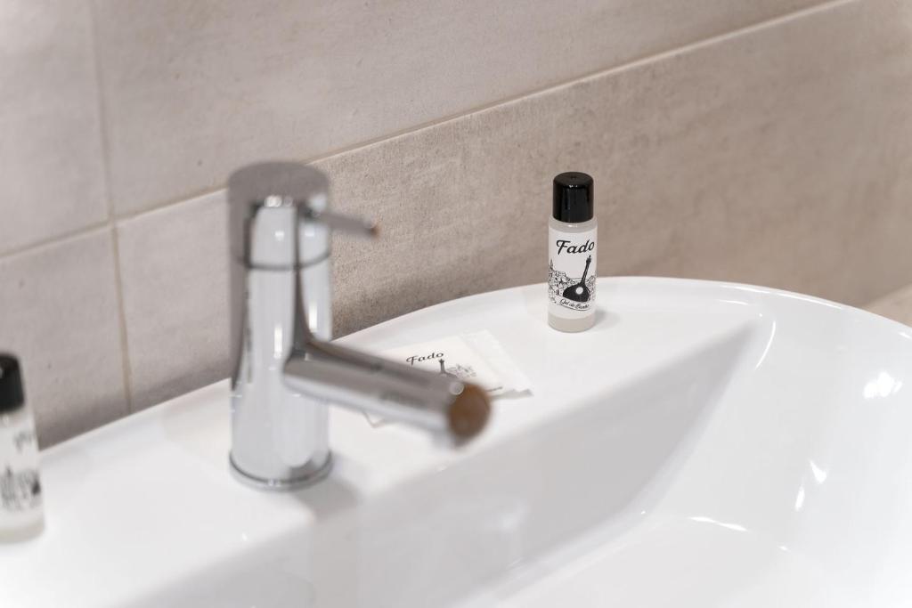 a bathroom sink with a faucet and a bottle of toothpaste at Quinta das Andorinhas in Carvoeiro