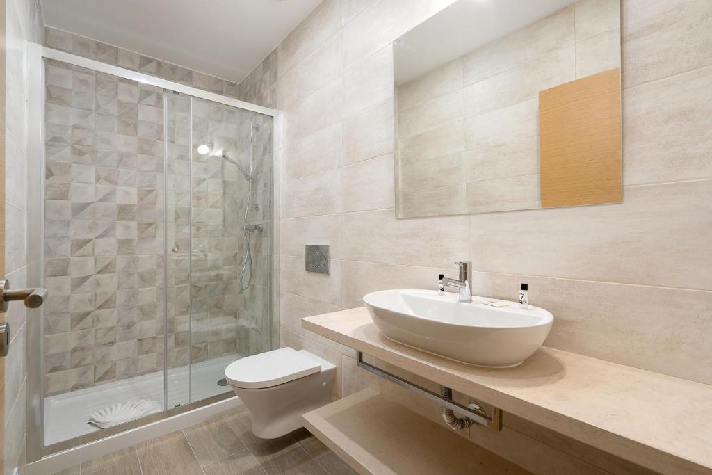 a bathroom with a sink and a toilet and a shower at Quinta das Andorinhas in Carvoeiro