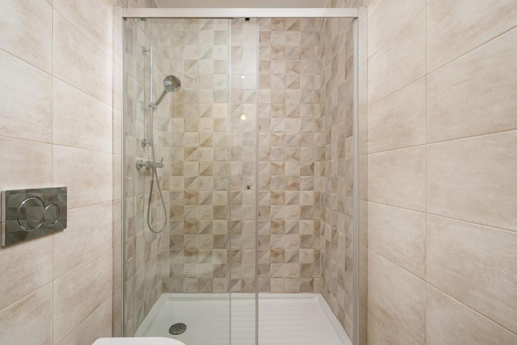 a bathroom with a shower with a toilet and a tub at Quinta das Andorinhas in Carvoeiro