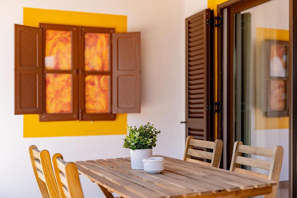 a wooden table with chairs and a potted plant on it at Quinta das Andorinhas in Carvoeiro