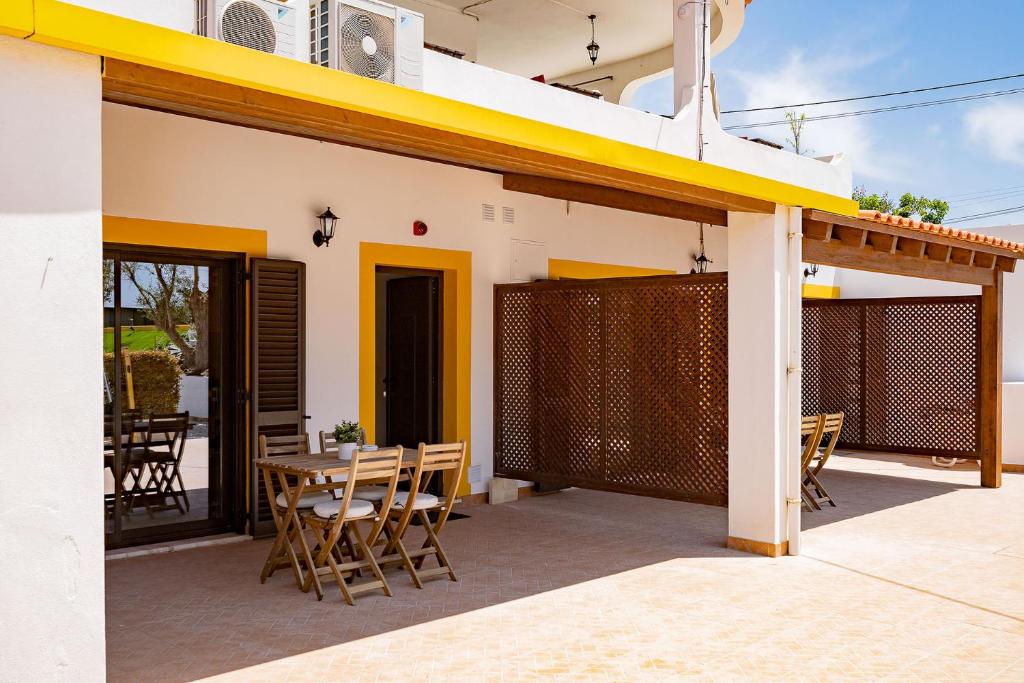 a patio with a table and chairs on a house at Quinta das Andorinhas in Carvoeiro
