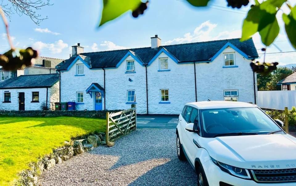 una casa blanca con un coche aparcado delante de ella en Pen Y Bont Cottage, en Llanuwchllyn