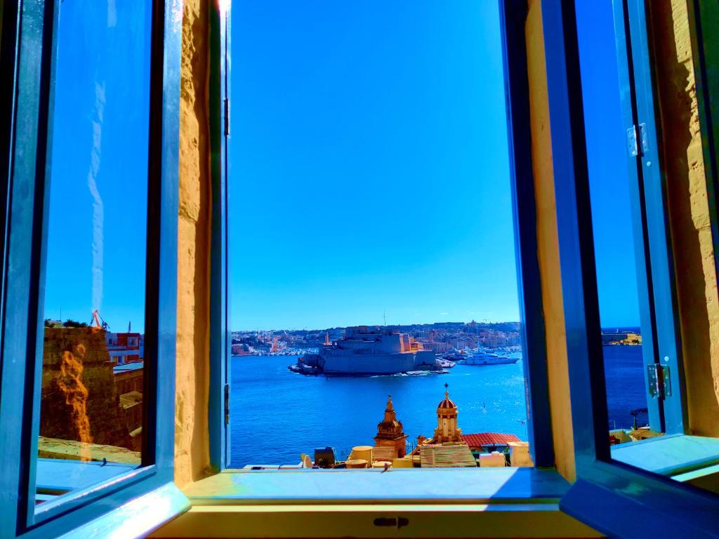 una finestra con vista su una nave in acqua di Oasis 22 Savynomad Harbour Residences wow Views a La Valletta