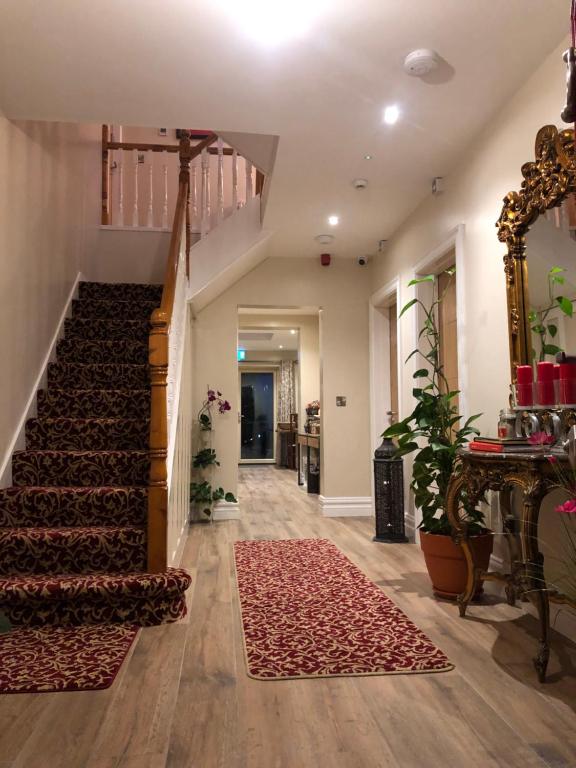a hallway of a home with a staircase and a rug at MapleHouse B&B in Drogheda