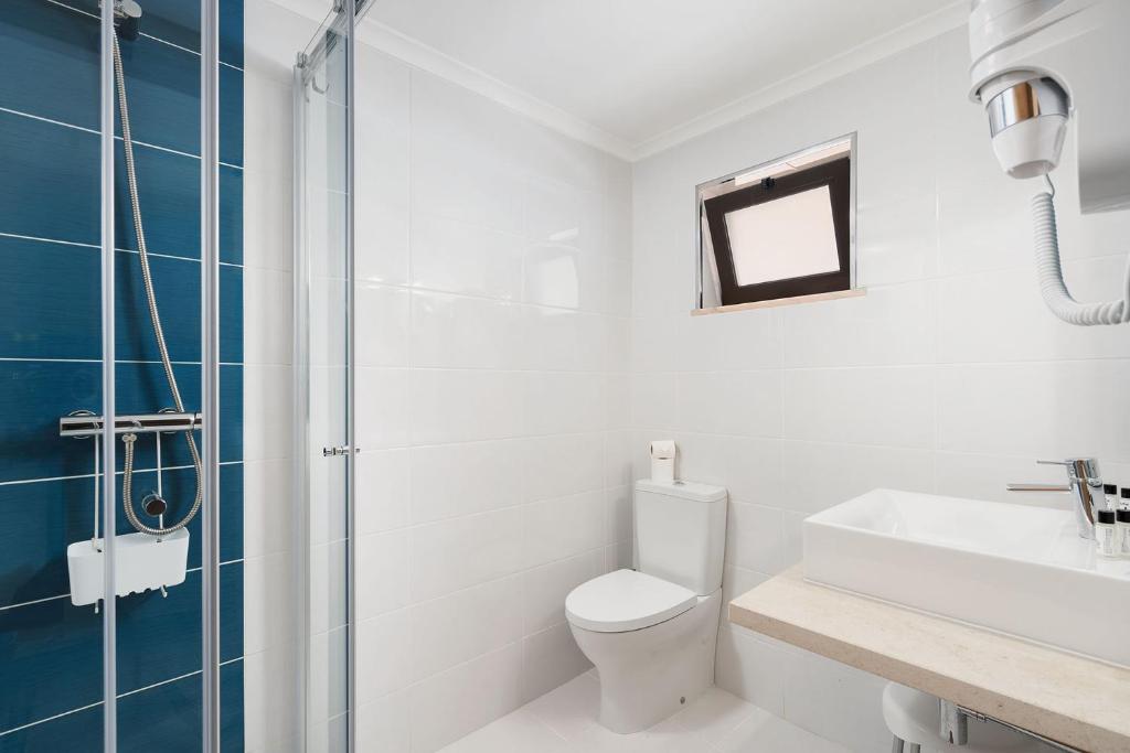 a bathroom with a toilet and a sink and a shower at Quinta das Andorinhas in Carvoeiro