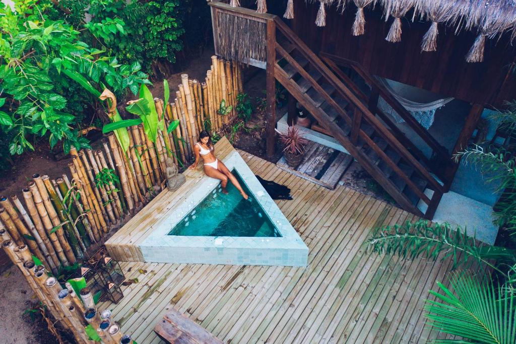 Eine Frau im Bikini steht im Pool in der Unterkunft Vila Fruta Pão in Caraíva