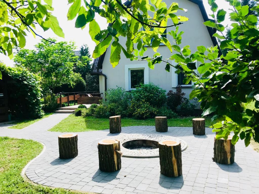 蒂科欽的住宿－Na szlaku - Leśniki 17，花园设有圆形休息区,配有树 ⁇ 凳