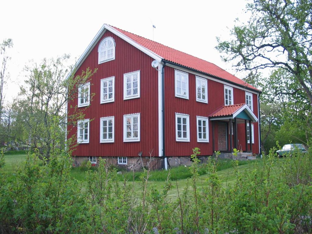 um celeiro vermelho com telhado vermelho e janelas brancas em Spjutsbygds Gårds Bed and Breakfast em Rödeby