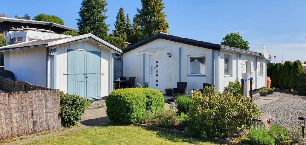 een wit huis met een garage in een tuin bij Ferienhaus " Silly " am schönen Listersee in Meinerzhagen