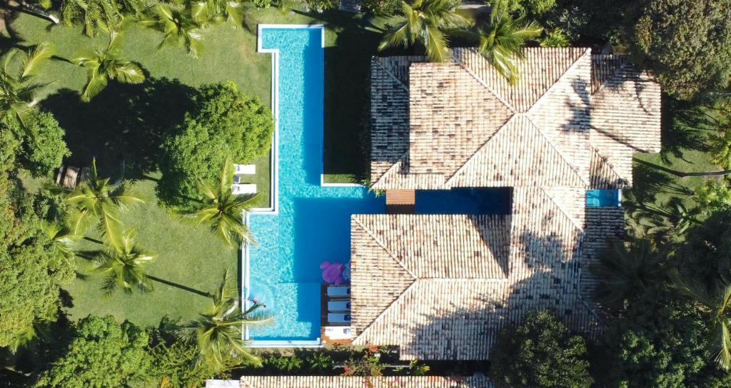 una vista aérea de una piscina frente a una casa en Paraíso Casa Branca en Arraial d'Ajuda