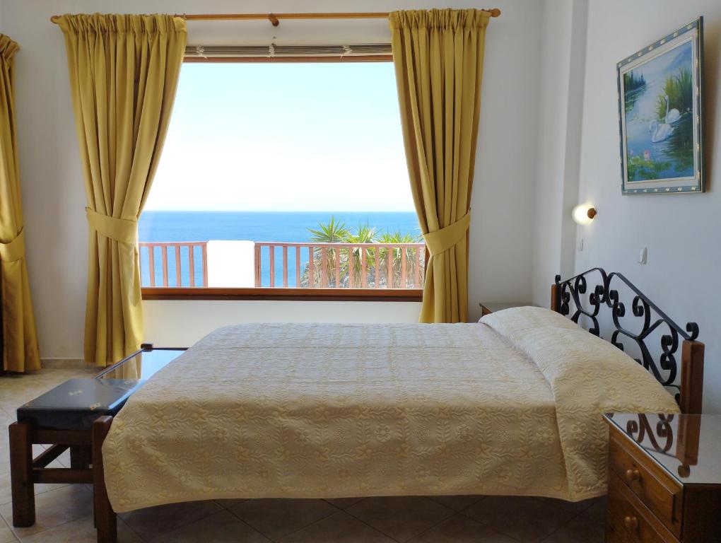 a bedroom with a bed and a view of the ocean at Olympos Studios in Amoopi