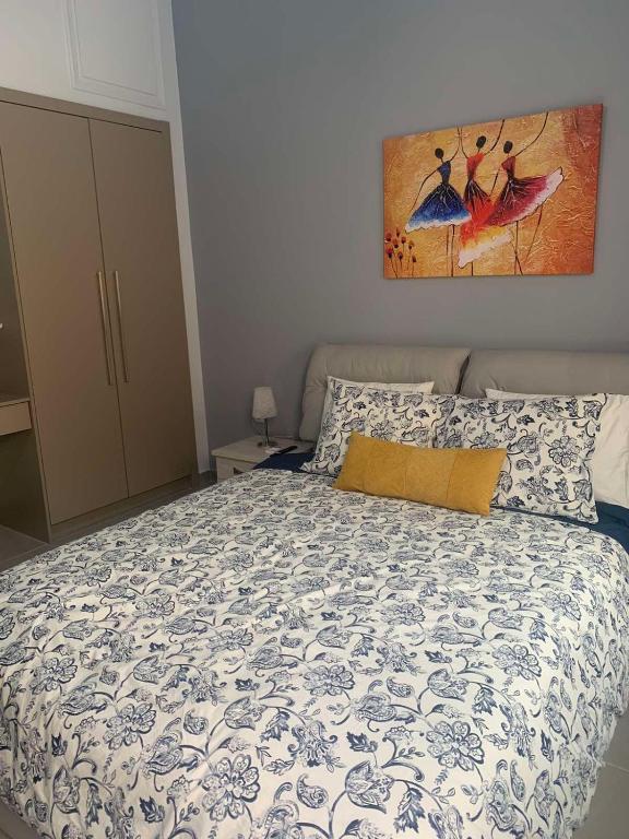 een slaapkamer met een bed met een blauw en wit dekbed bij Georgia's house in Ária