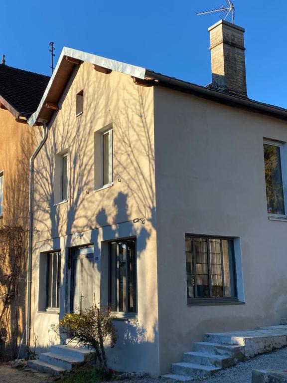 a white house with stairs in front of it at Gite l ORIGINE in Ornans