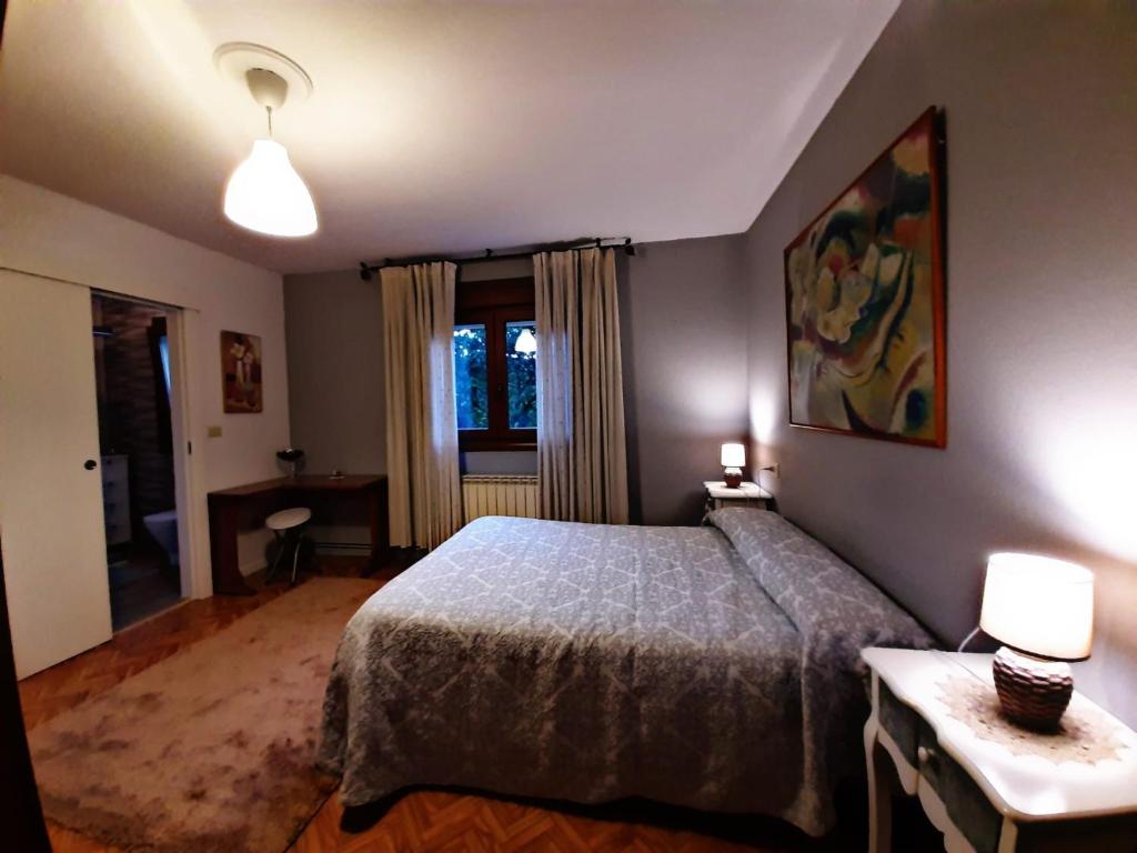 Vila do Río في دومبريا: غرفة نوم بسرير ومصباحين ونافذة