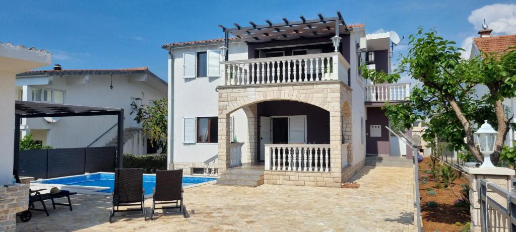 eine Villa mit einem Pool und einem Haus in der Unterkunft Kuća za odmor Angelina in Primošten