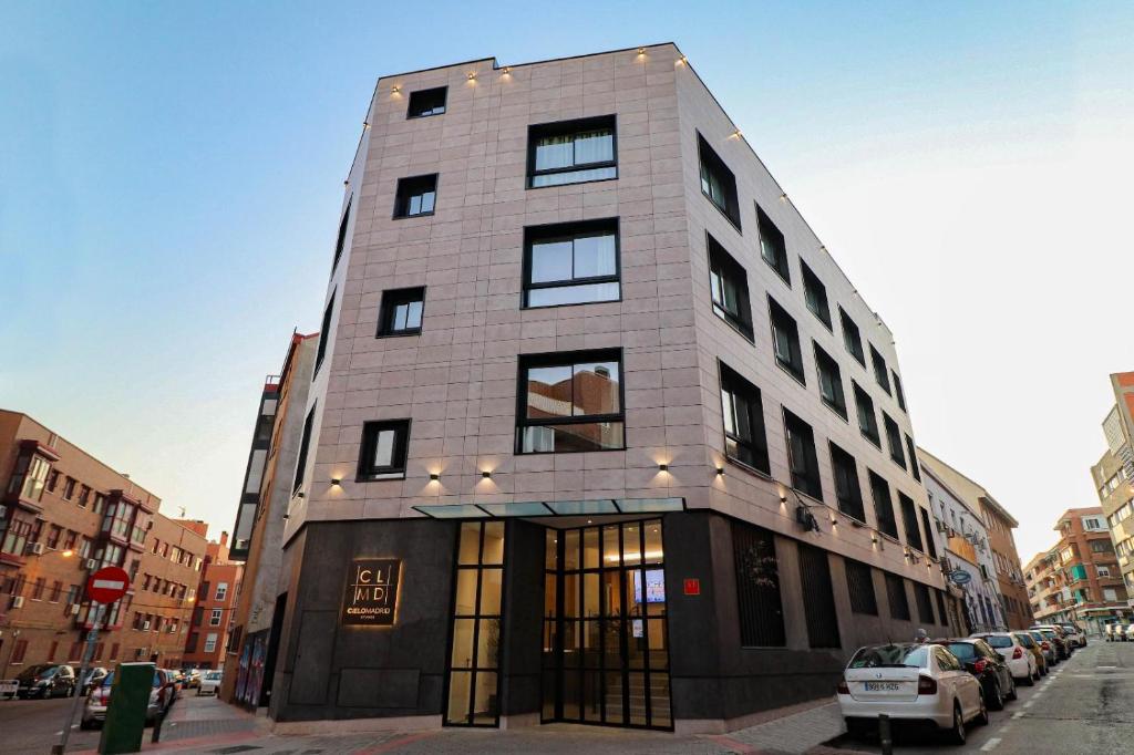 a tall building on a city street with parked cars at Studios Cielo Madrid in Madrid