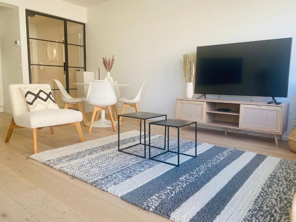 奧斯坦德的住宿－Chez Coceau - Luxery apartment with sea view，客厅配有2张桌子和平面电视