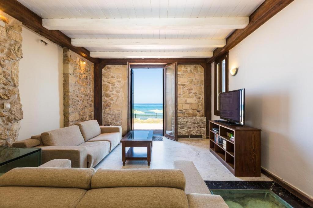a living room with two couches and a television at Volakas Beachfront Suites in Rethymno