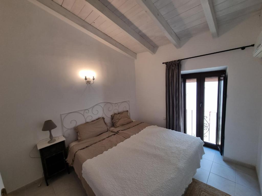 a white bedroom with a bed and a window at Town house with roof terrace - Old Town in Marbella