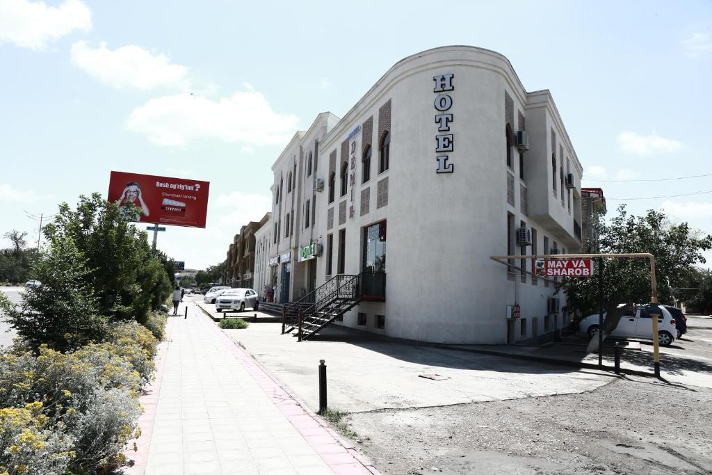 a white building with a sign on the side of it at Demir Hotel Bukhara in Bukhara