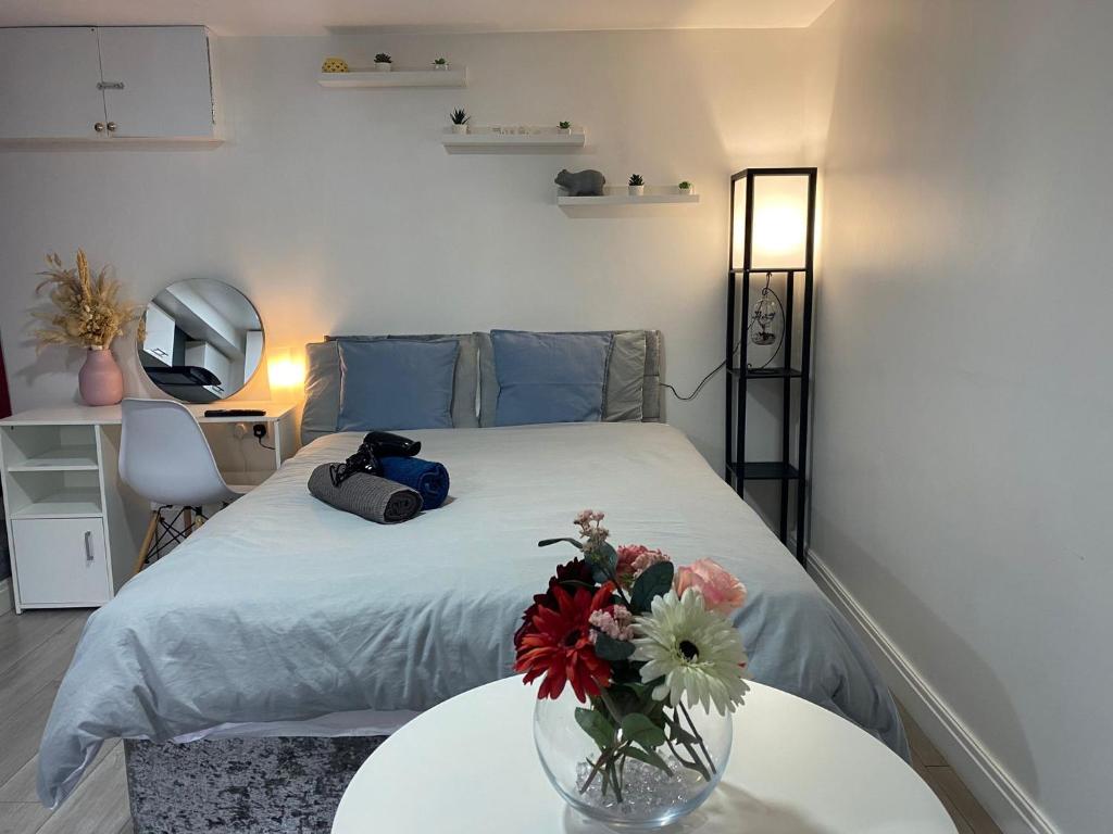 um quarto com uma cama com um vaso de flores sobre uma mesa em Charming, cosy hideaway with free WiFi, parking em Roundhay