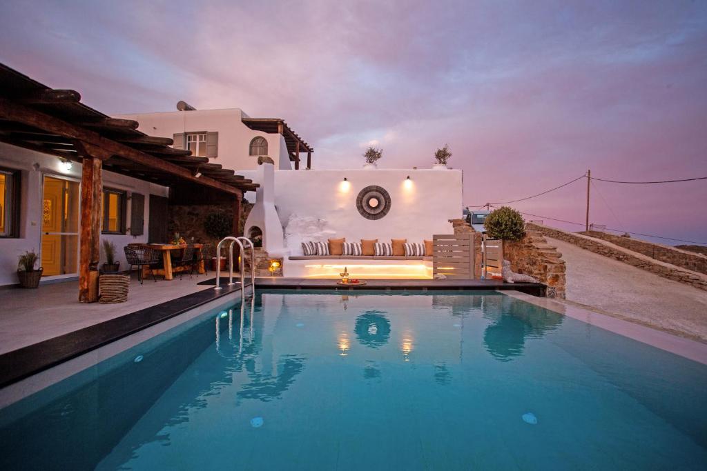 a villa with a swimming pool in front of a house at Infinity View Villas Mykonos in Kalo Livadi