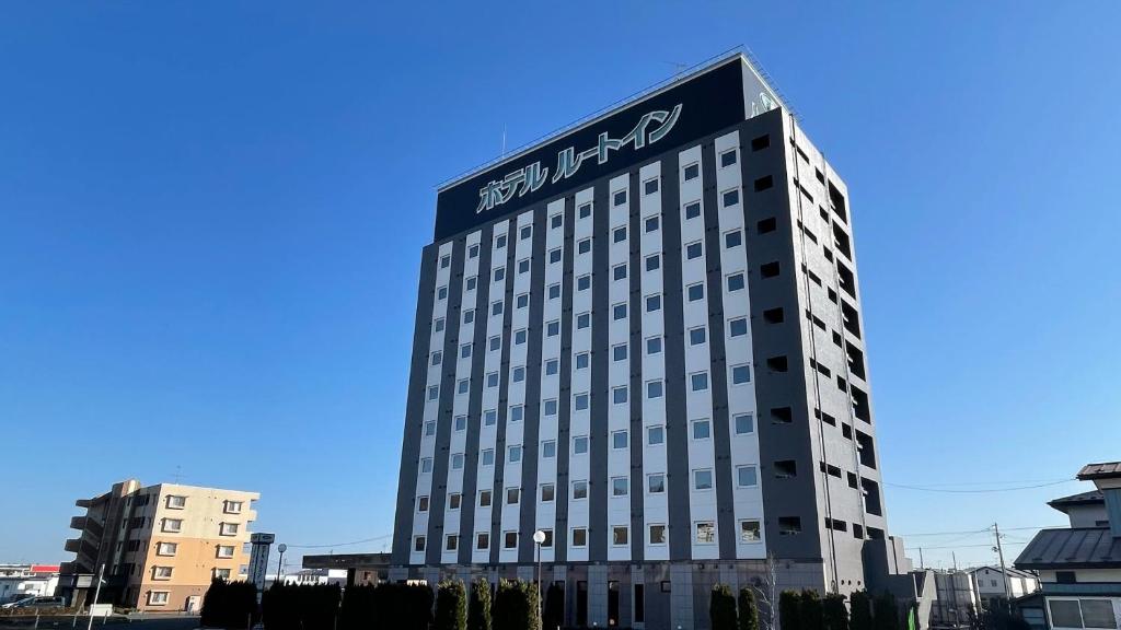 Un bâtiment avec un panneau en haut dans l'établissement Hotel Route-Inn Ichinoseki Inter, à Ichinoseki