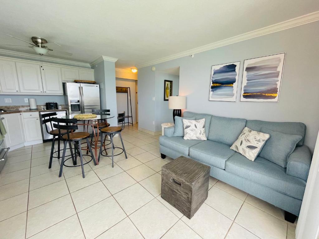 a living room with a blue couch and a kitchen at #1203 Lovers Key Beach Club in Fort Myers Beach