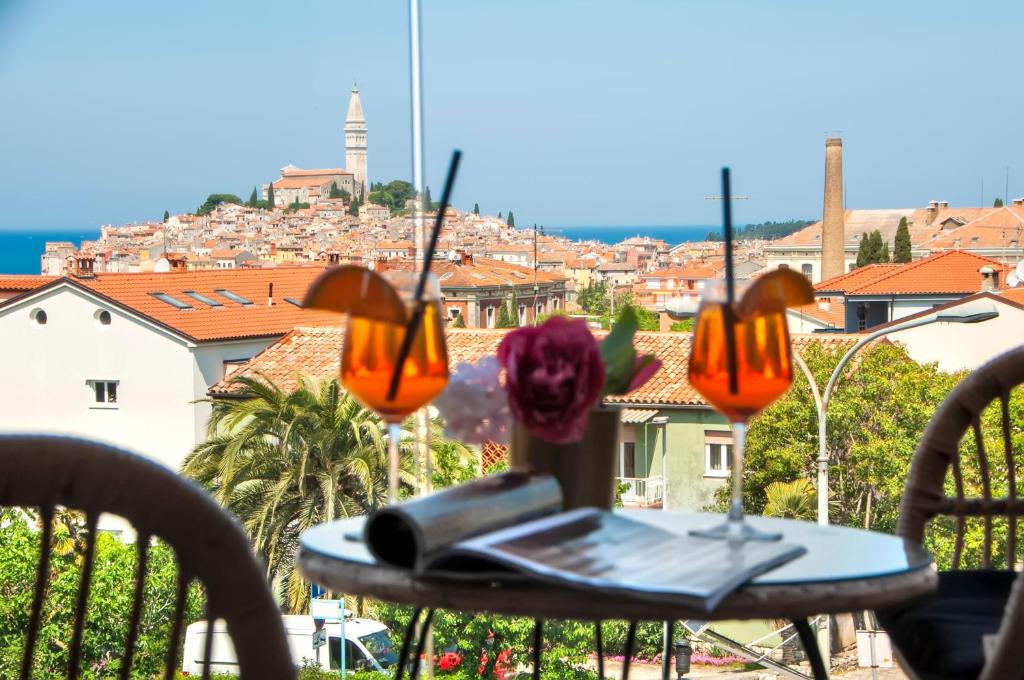 a table with a laptop on top of a balcony at Boutique Residence Arion in Rovinj